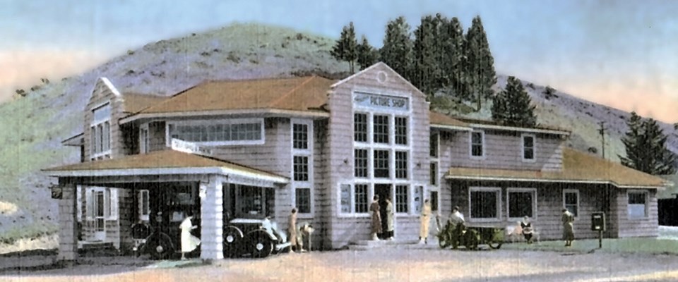 Visitors in front of a building with many windows in front of a mountain Visitors in front of a building with many windows in front of a mountain
