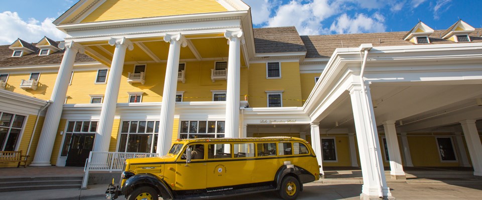 A historic yellow vehicle in front of a historic yellow building A historic yellow vehicle in front of a historic yellow building