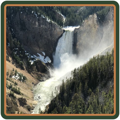 A waterfall crashes down into a steep, yellow-walled canyon.