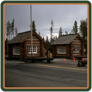 Two wooden, log structures stand on the road.