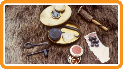Assorted tools of mountain men laid out on a fur.