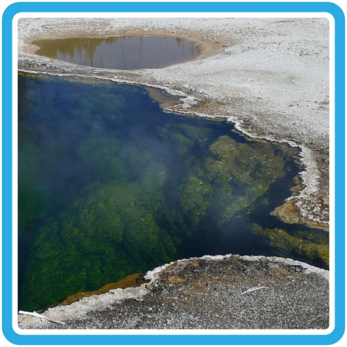 Deep blue pool of hot water surrounded by a barren, gray ground.