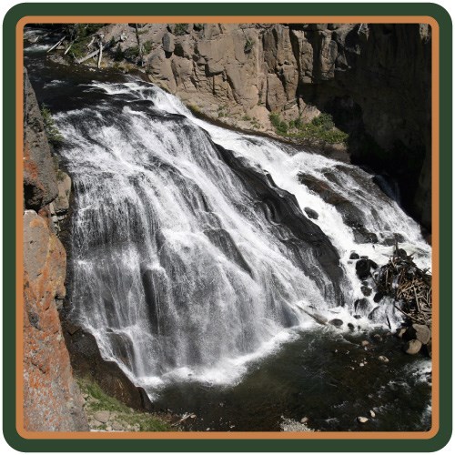 A waterfall cascades down brown-gray rock that forms part of the Yellowstone Caldera rim.