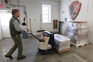 A person moving boxes stacked on a pallet
