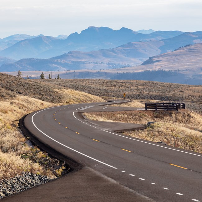 a paved road winding through a mountainous landscape