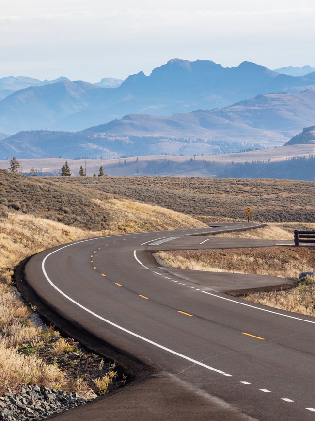 a paved road winding through a mountainous landscape