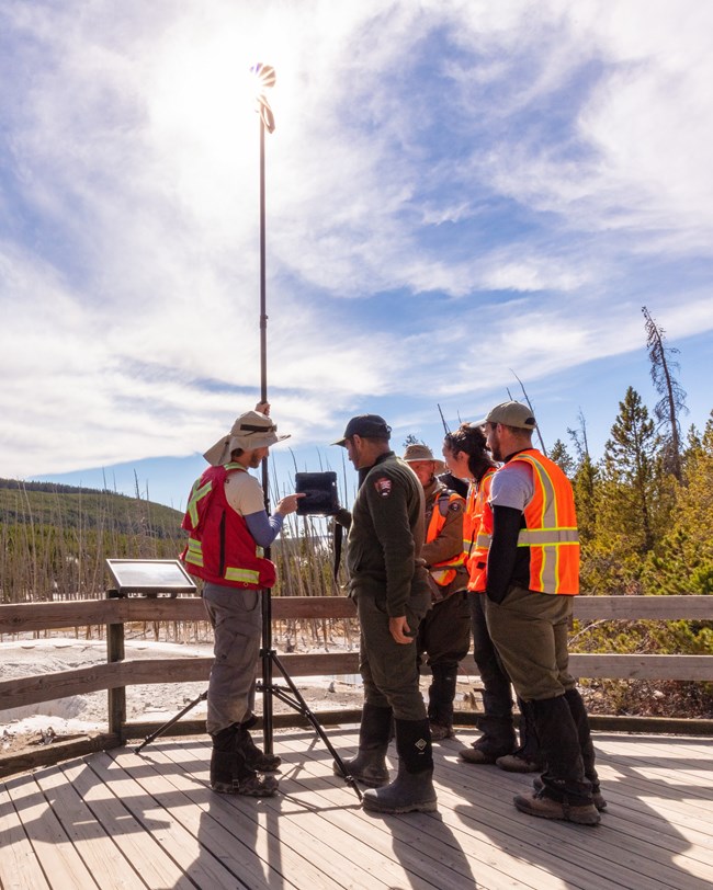 park rangers using equipment to map a nearby thermal feature