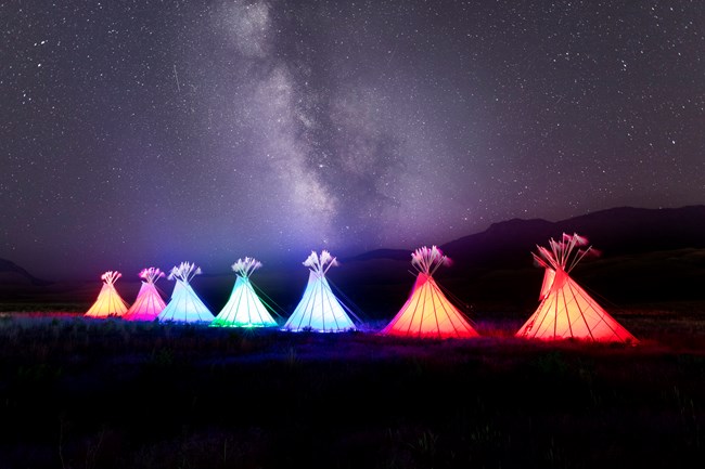 Illuminated teepees and Milky Way