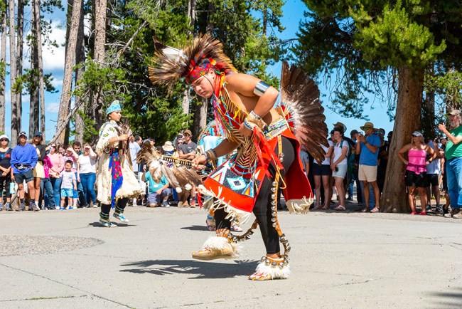 Tribal dancers in full regalia at Old Faithful