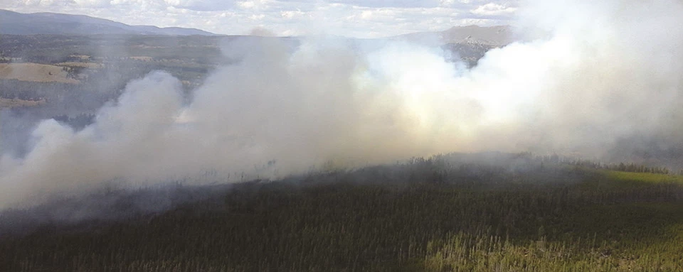 28884029841_bcef48eadd_k Smoke rises from a forested landscape.