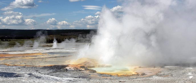 Orange, blue, and white pools surround erupting and steaming geysers Orange, blue, and white pools surround erupting and steaming geysers