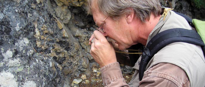 A man holds an object closely to his eye A man holds an object closely to his eye