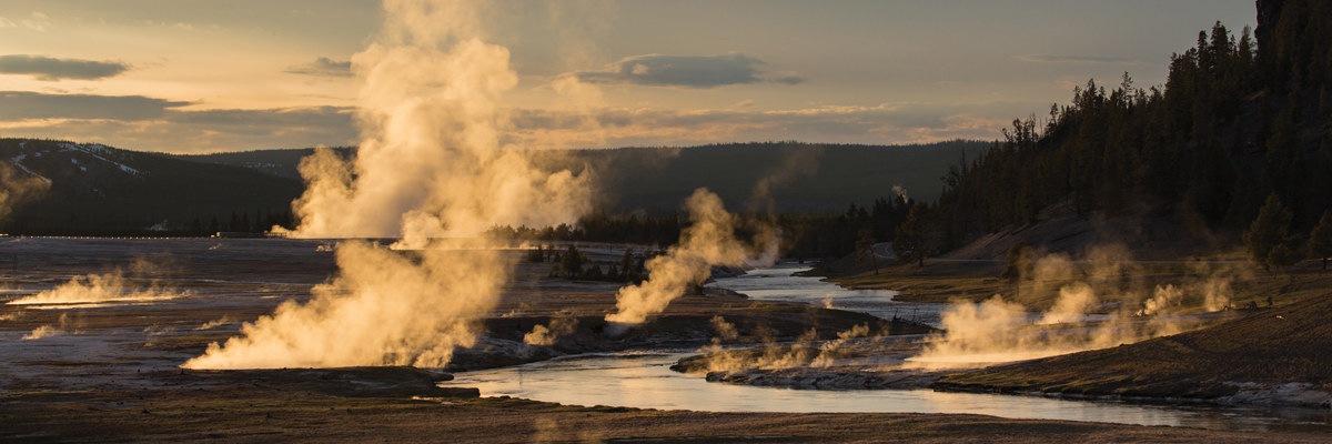 Steam illuminated by sunlight rises from the banks of a river Steam illuminated by sunlight rises from the banks of a river