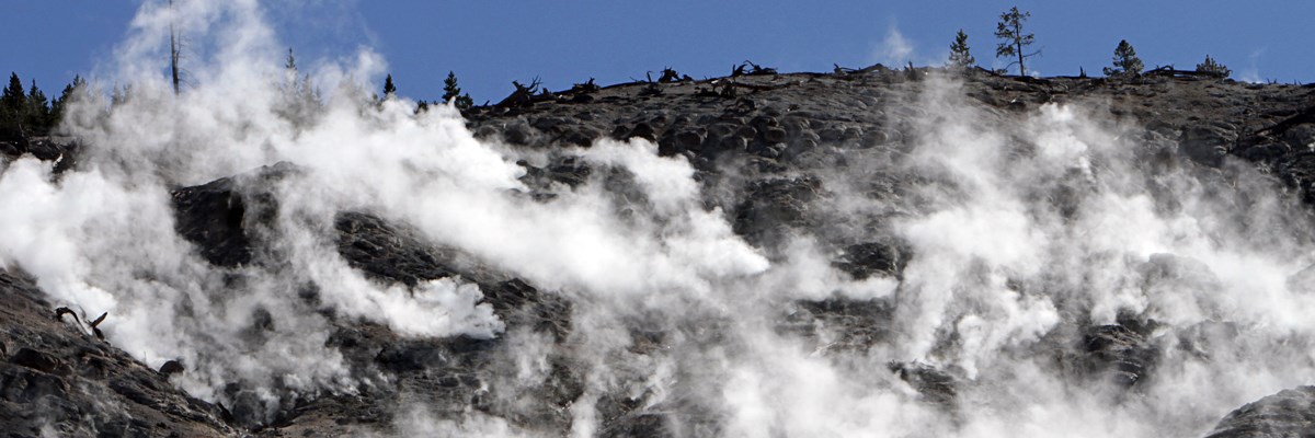 Steam rises from dark rocks Steam rises from dark rocks
