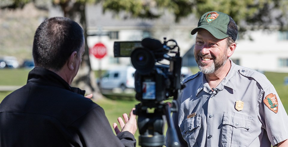 Park ranger being interviewed by journalists. Park ranger being interviewed by journalists.