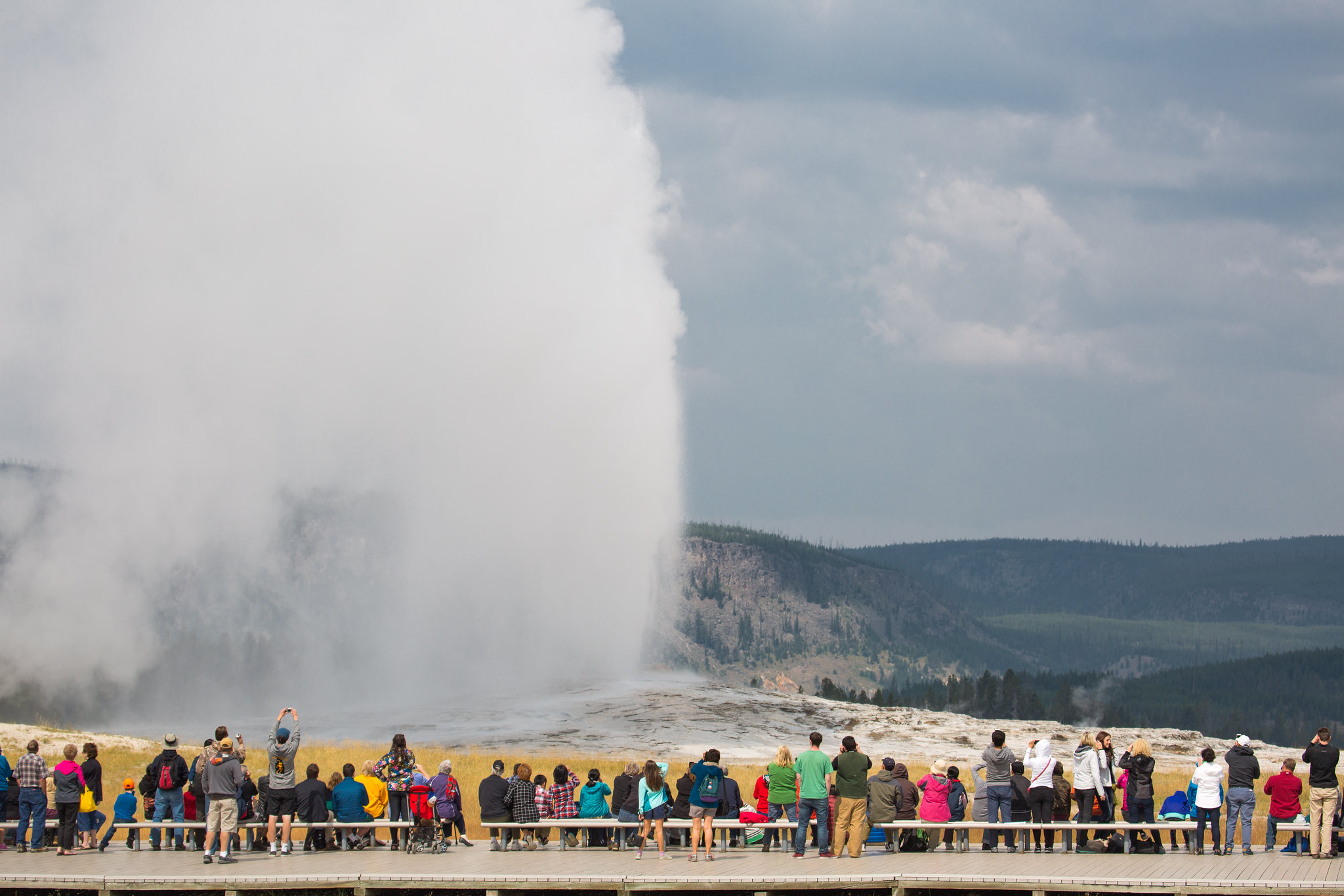 people watching an Old Faithful eruption