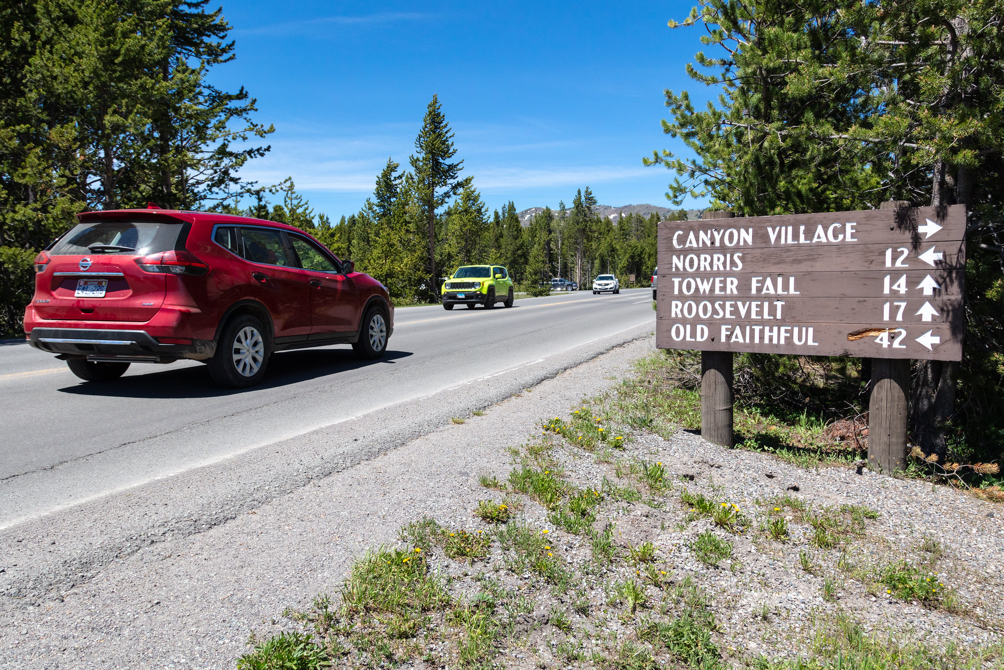 sign next to a road with cars driving by