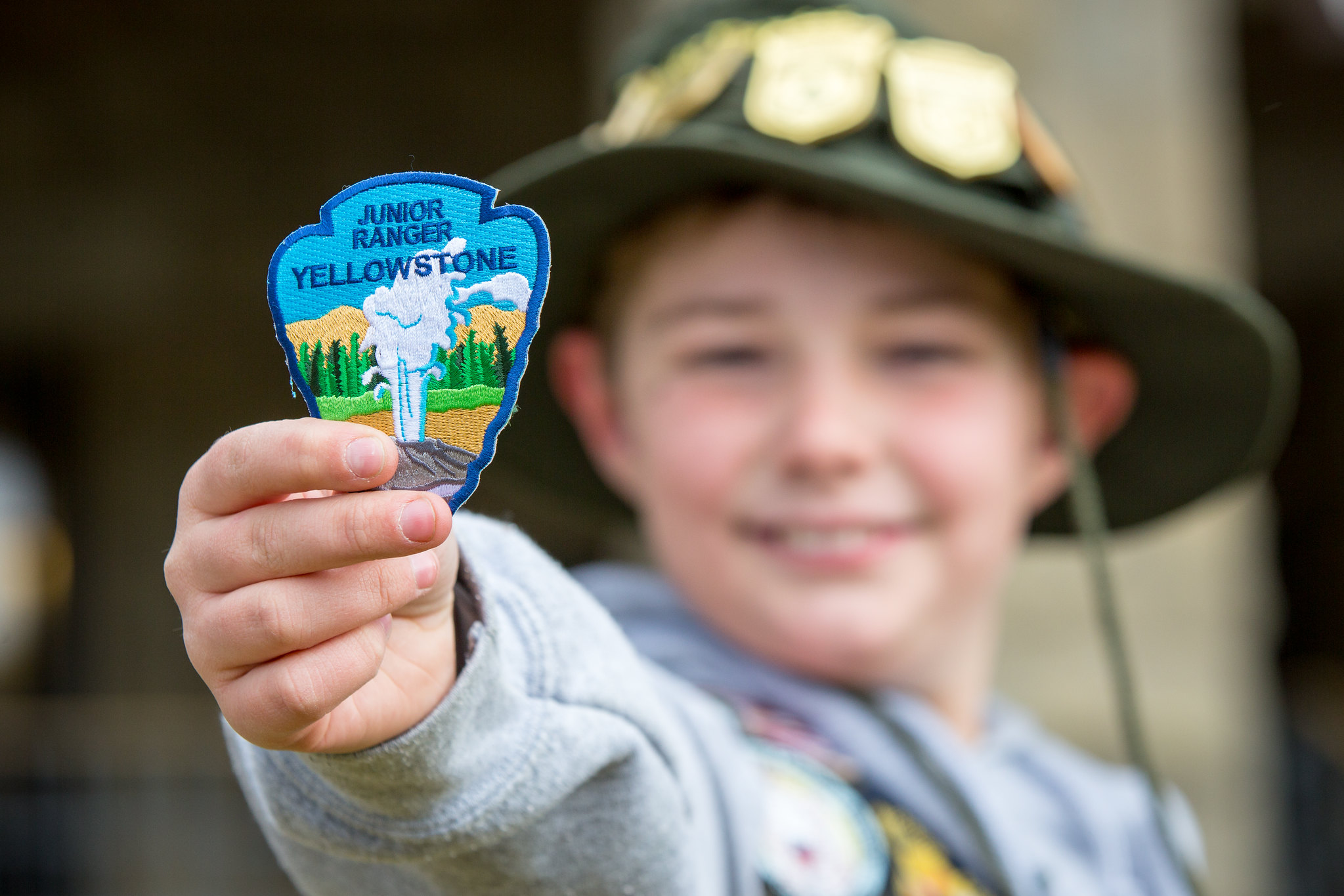 Junior ranger holds up patch