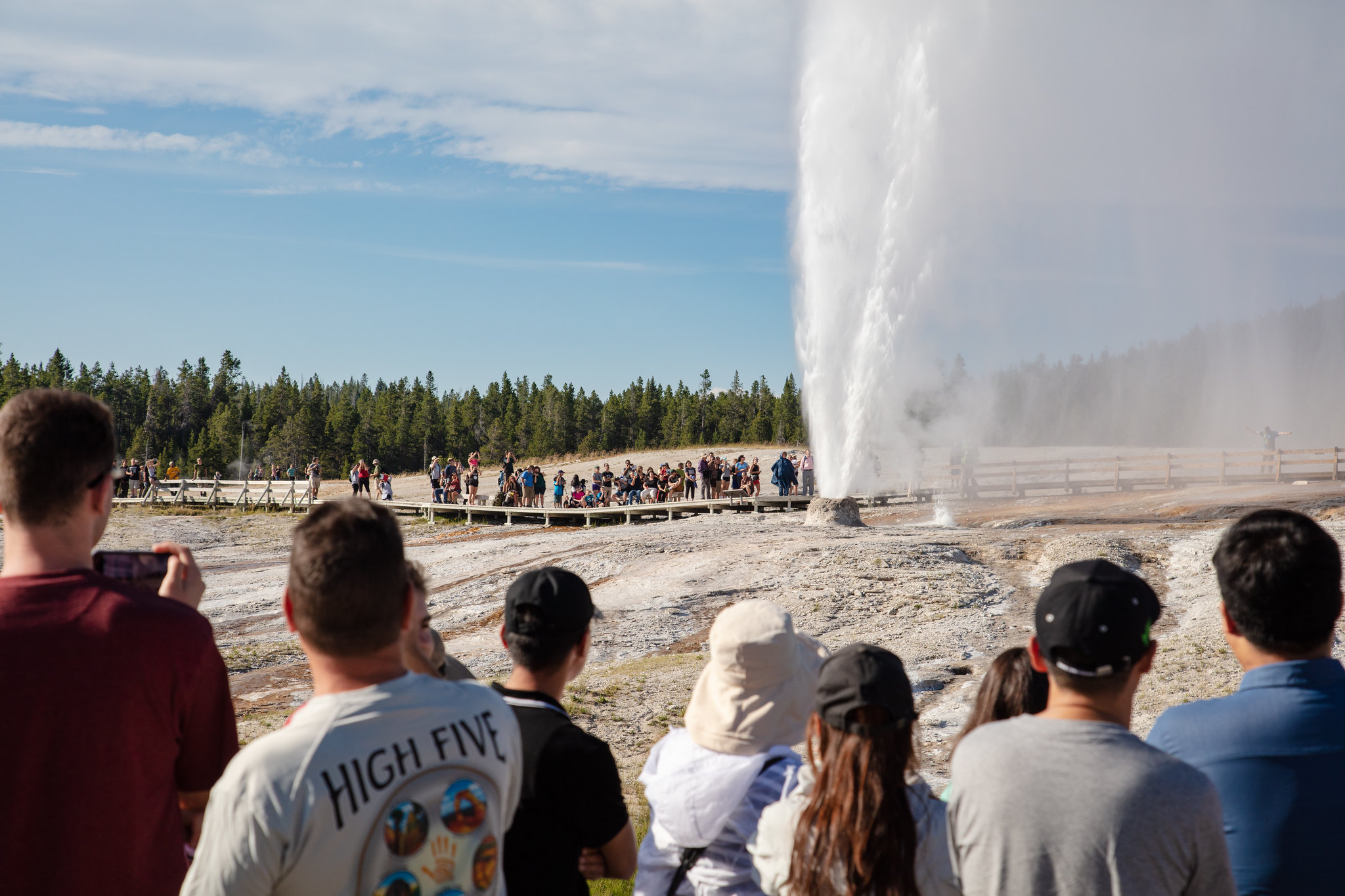 visitors watching geyser eruption