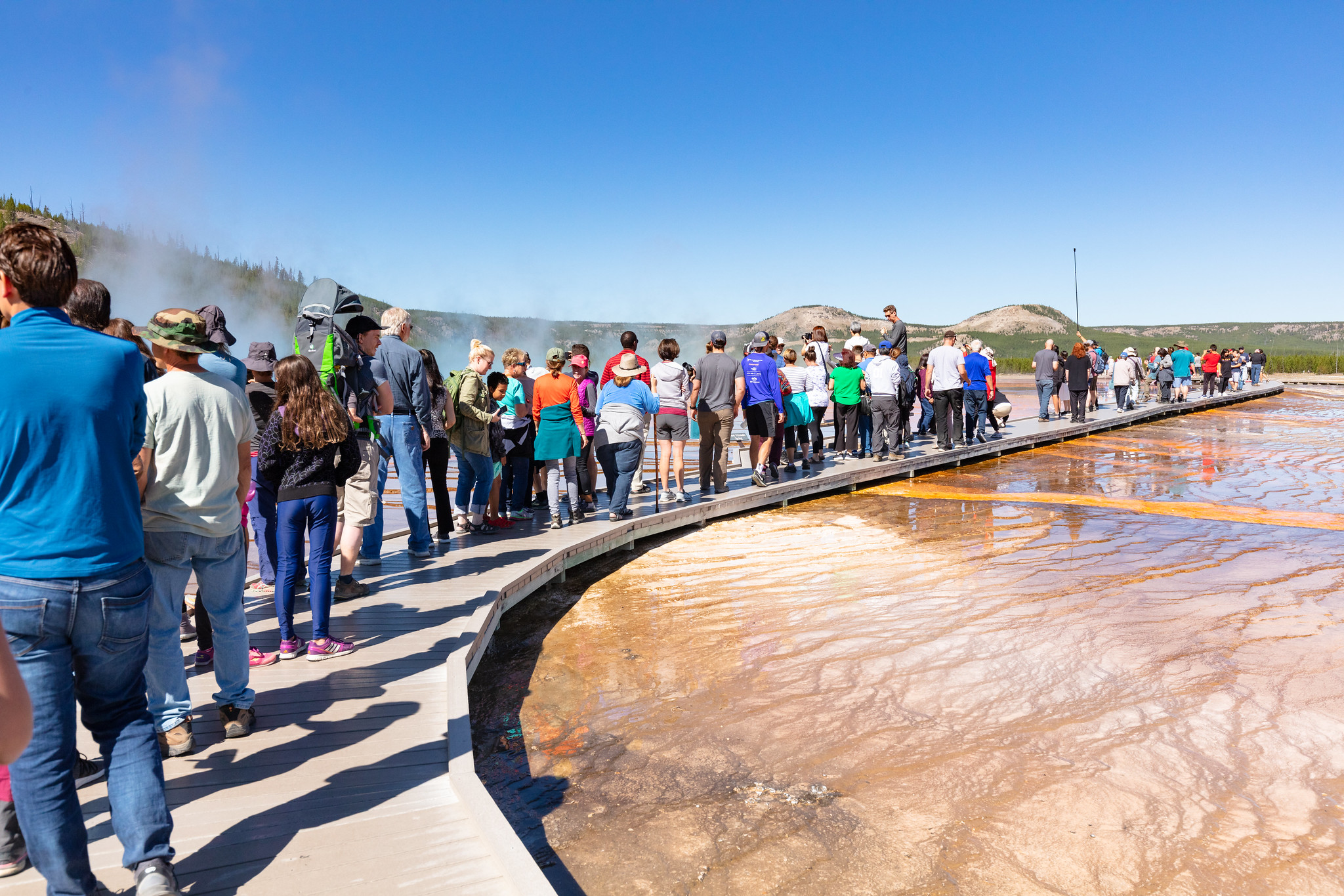 Crowd of visitors on boardwalk in thermal area