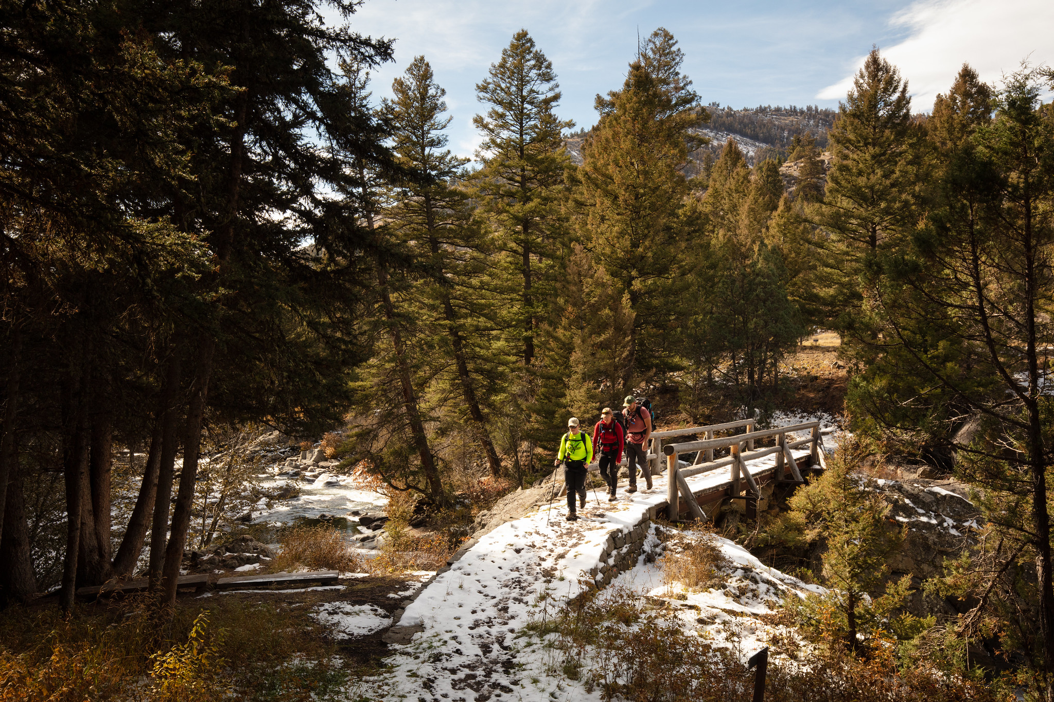 Hikers cross the Hellroaring Creek Bridge