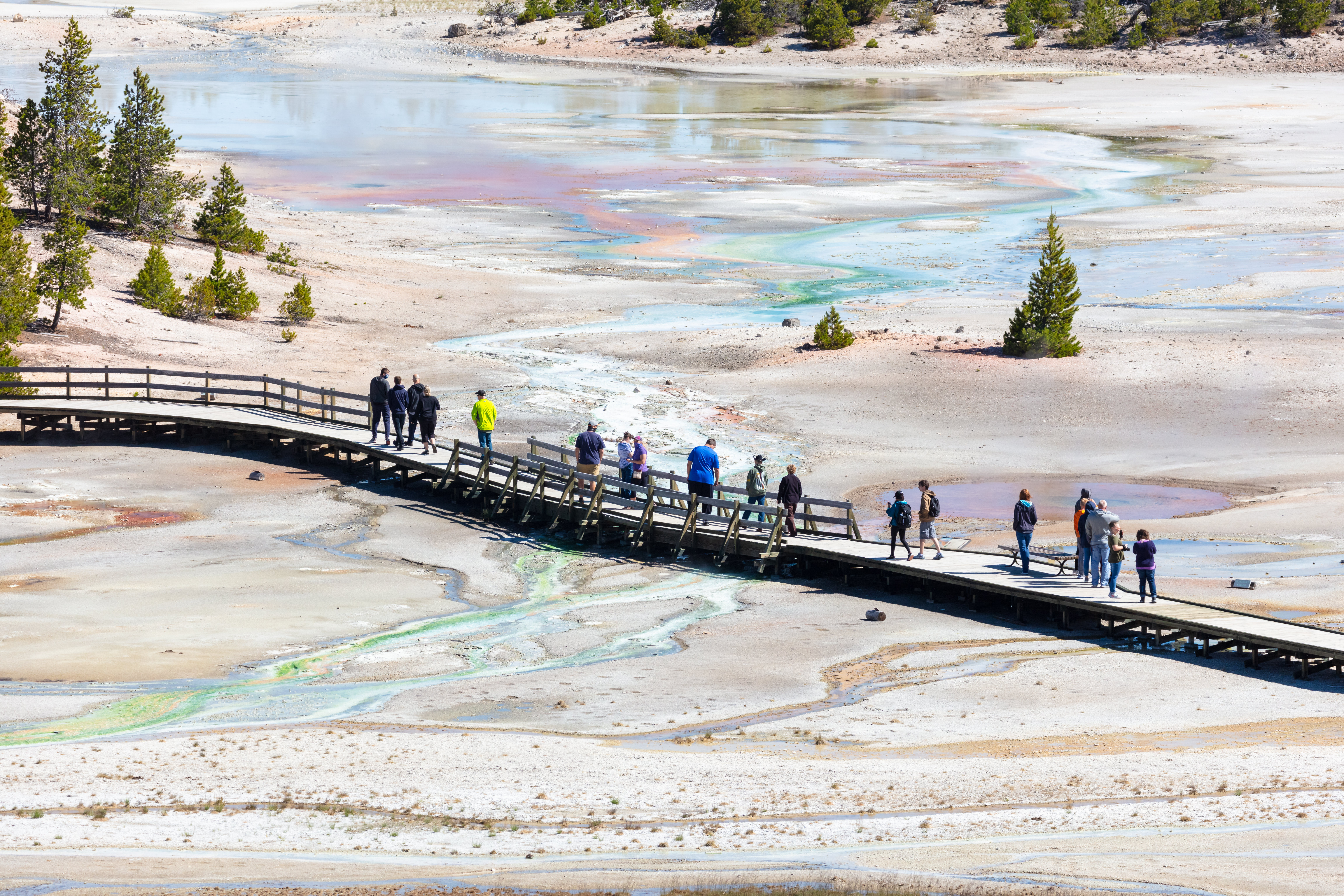 People walking on a boardwalk above a thermal area