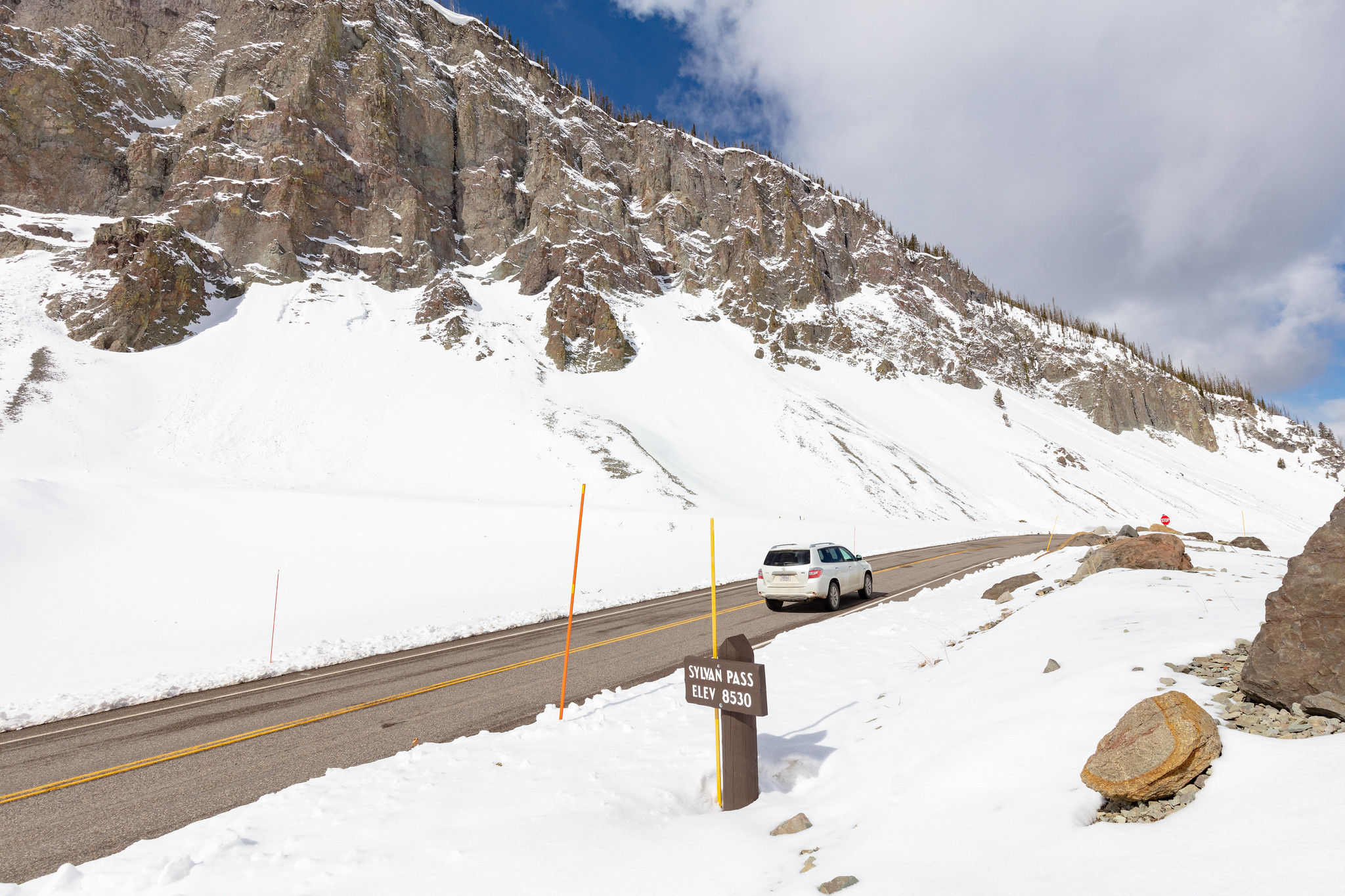 car driving on mountain road with snow on the sides