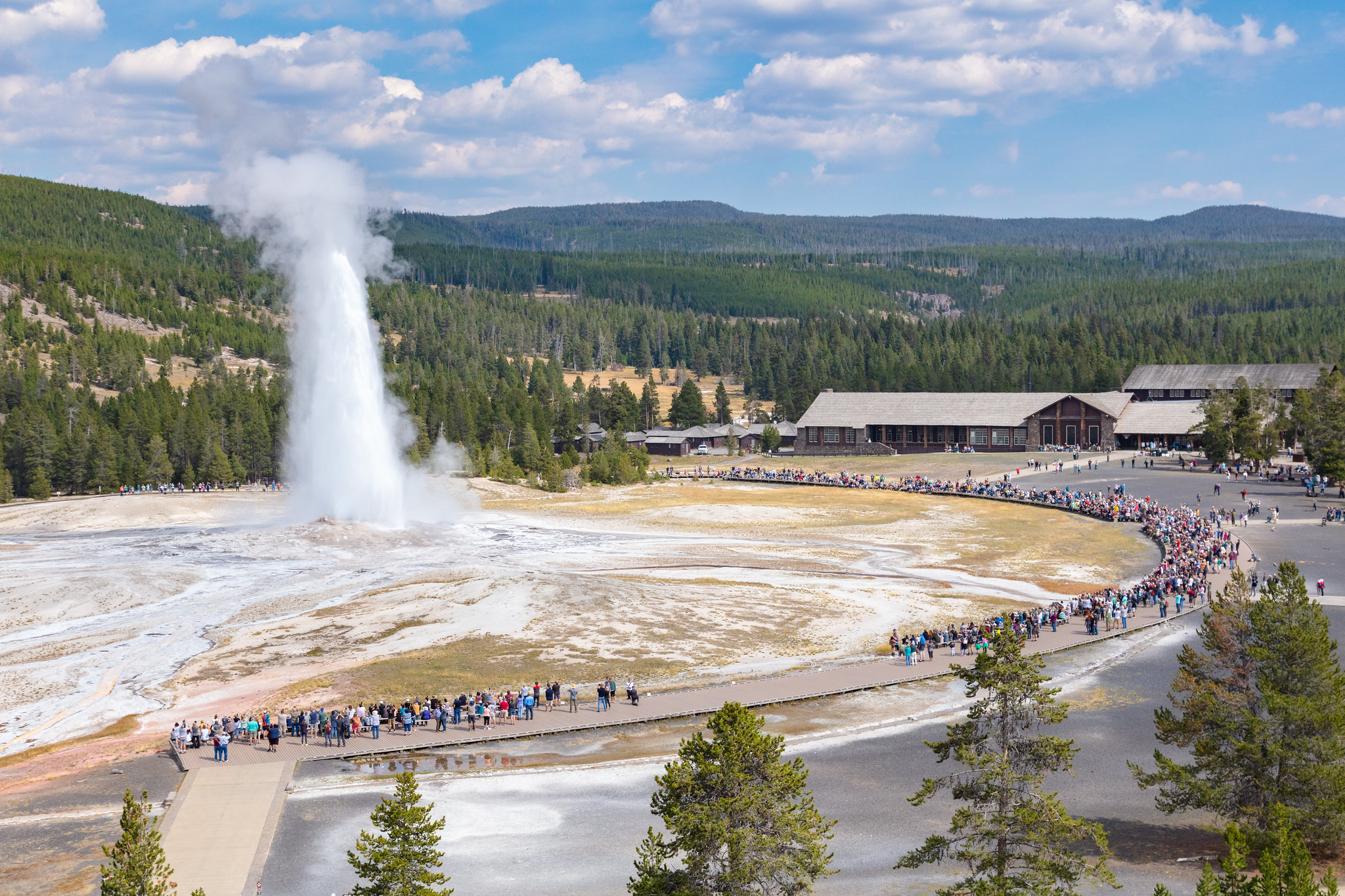visitors watching Old Faithful geyser erupt
