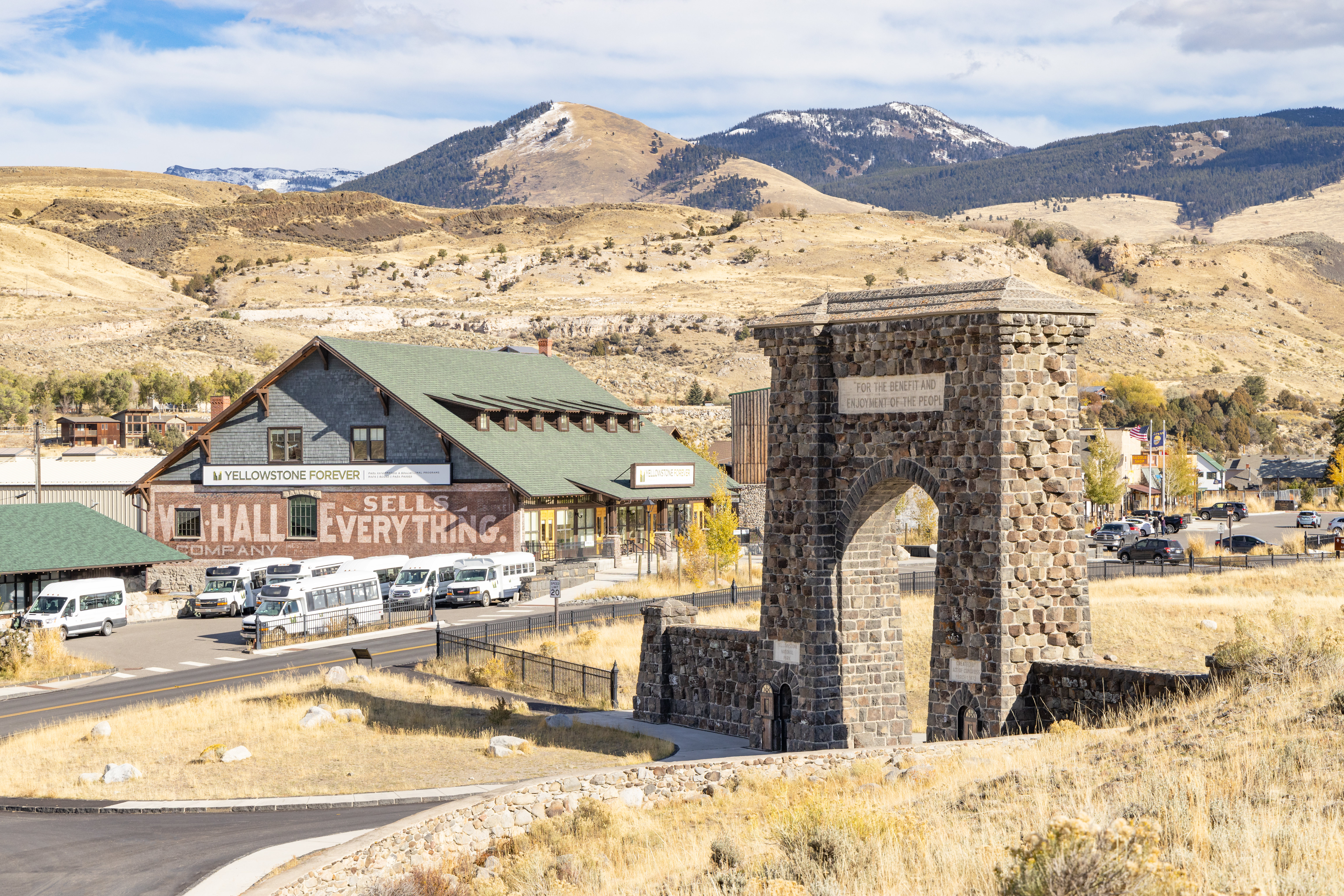 a large stone archway near historic buildings in a town