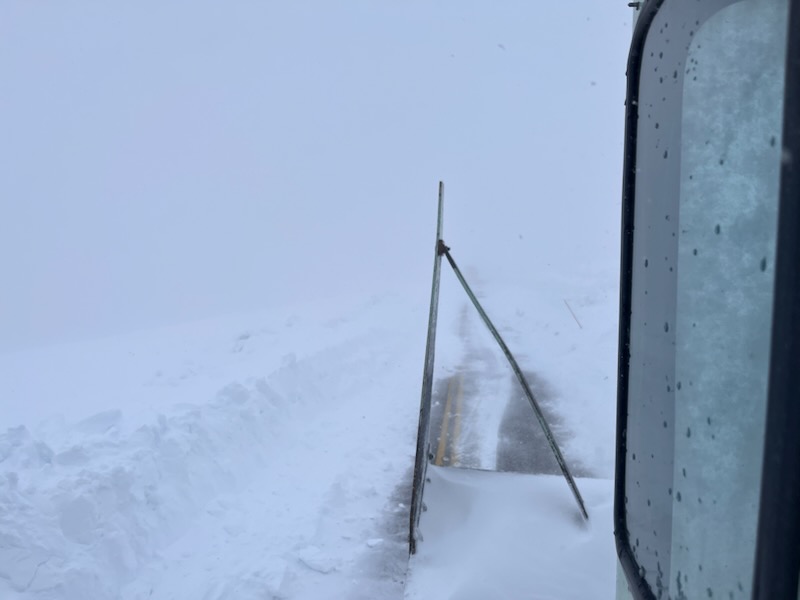 A snow plow moves snow on the road