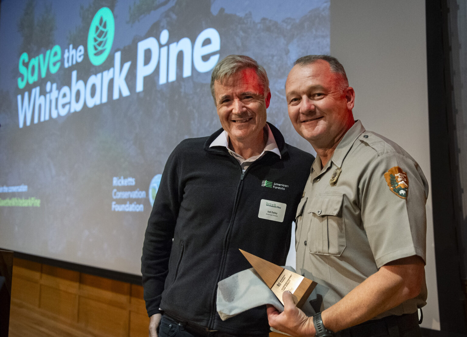 Jad Daley, President and CEO of American Forests, left, gives Cam Sholly, Superintendent of Yellowstone National Park, an award at the Museum of the Rockies on Thursday, Sept. 28, 2023, in Bozeman, Mont.