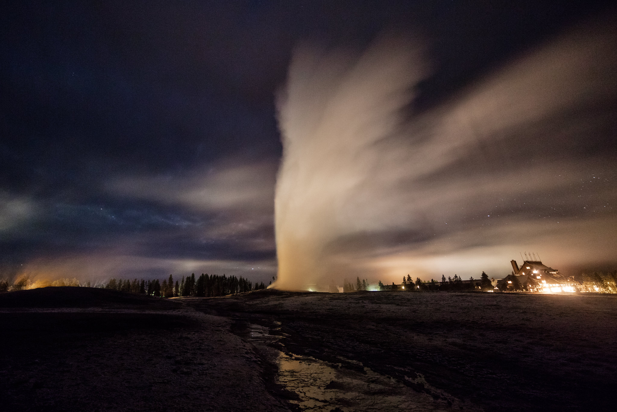 Old Faithful eruption on a cloudy evening