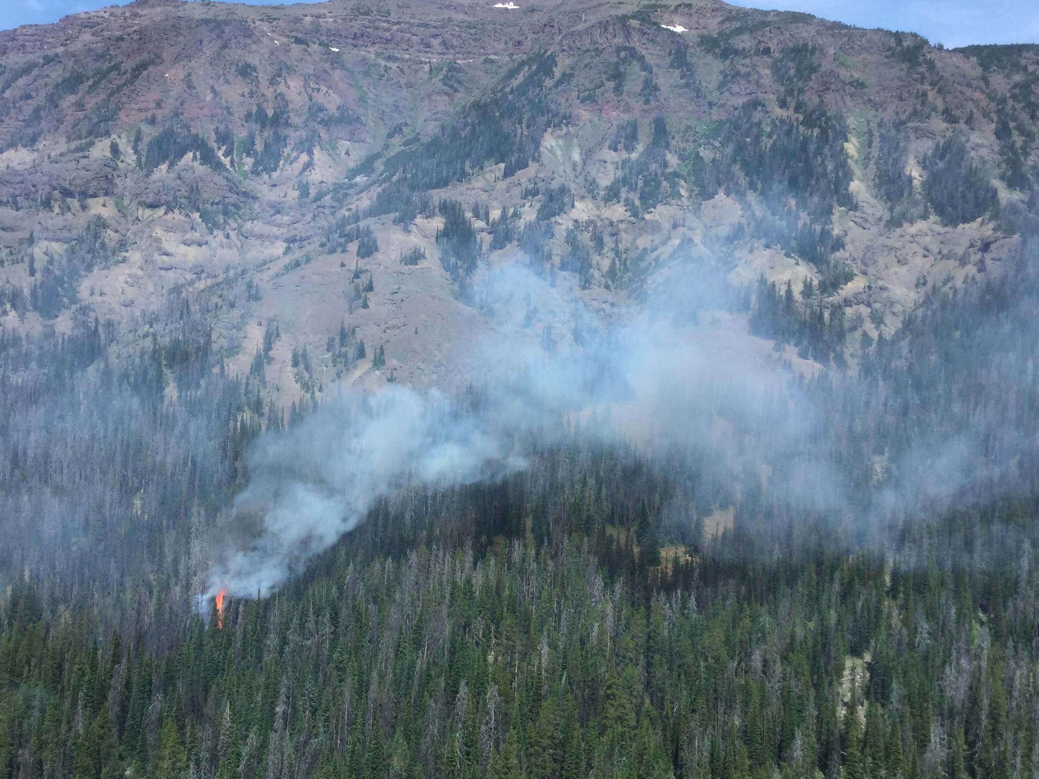 Pollux1 flames from a small wildfire in mountainous terrain