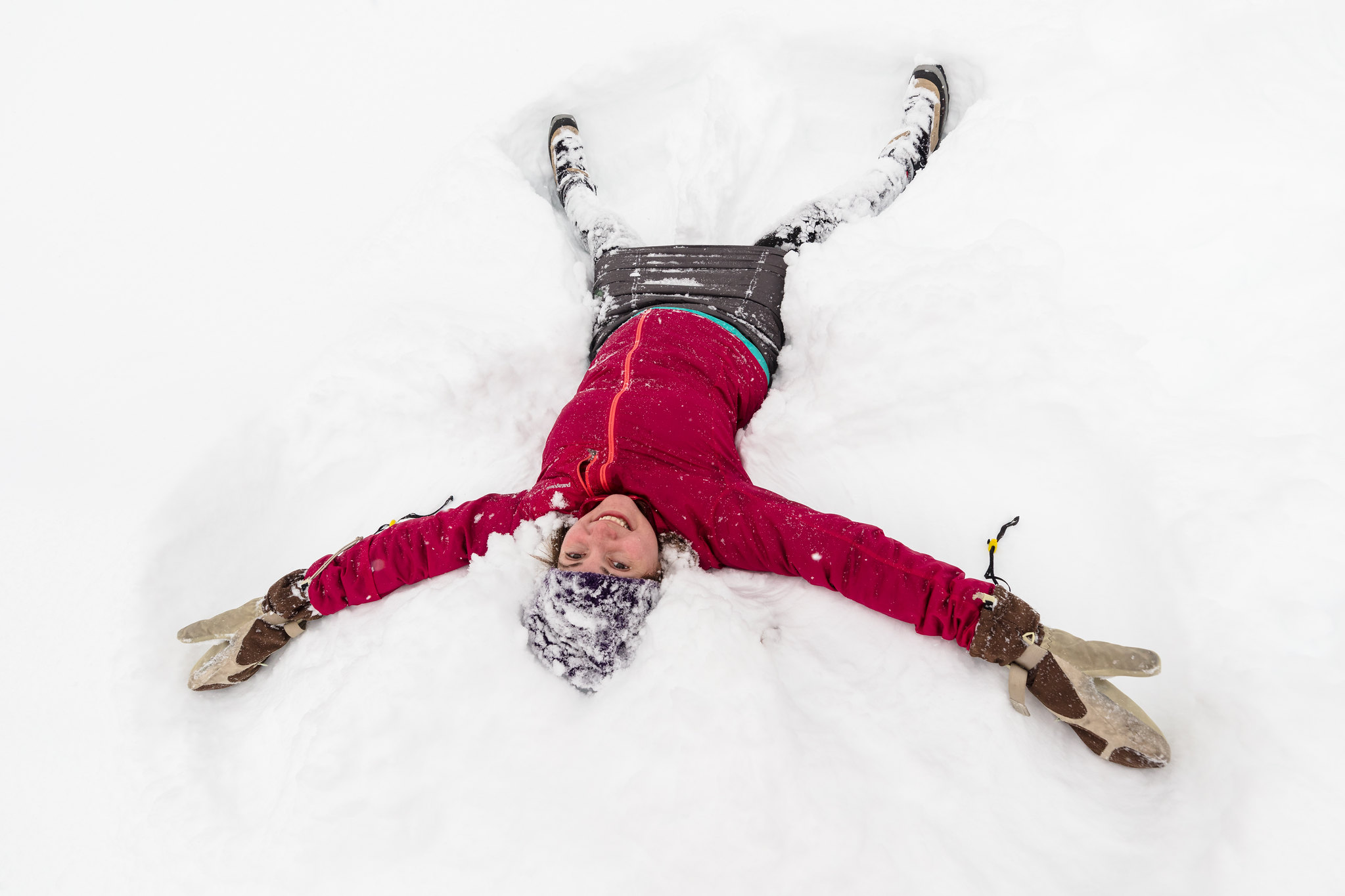 Snow angel woman making an angel in the snow