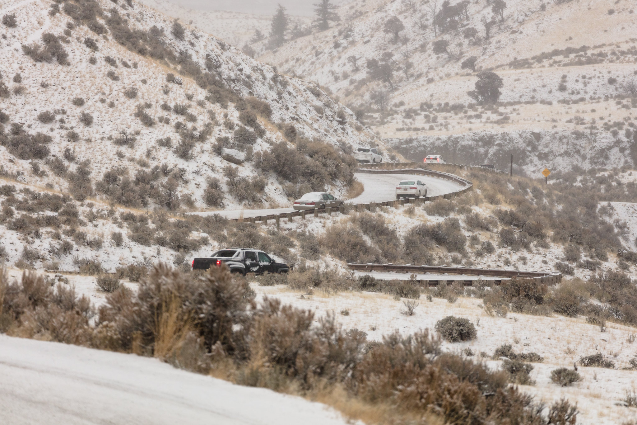 Cars driving on winding snowy road