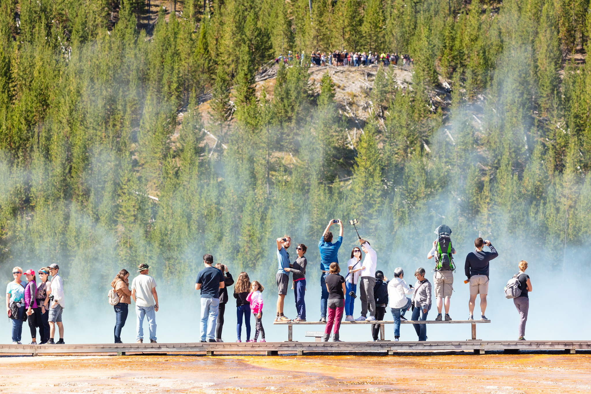 Visitors taking photos in geyser basin