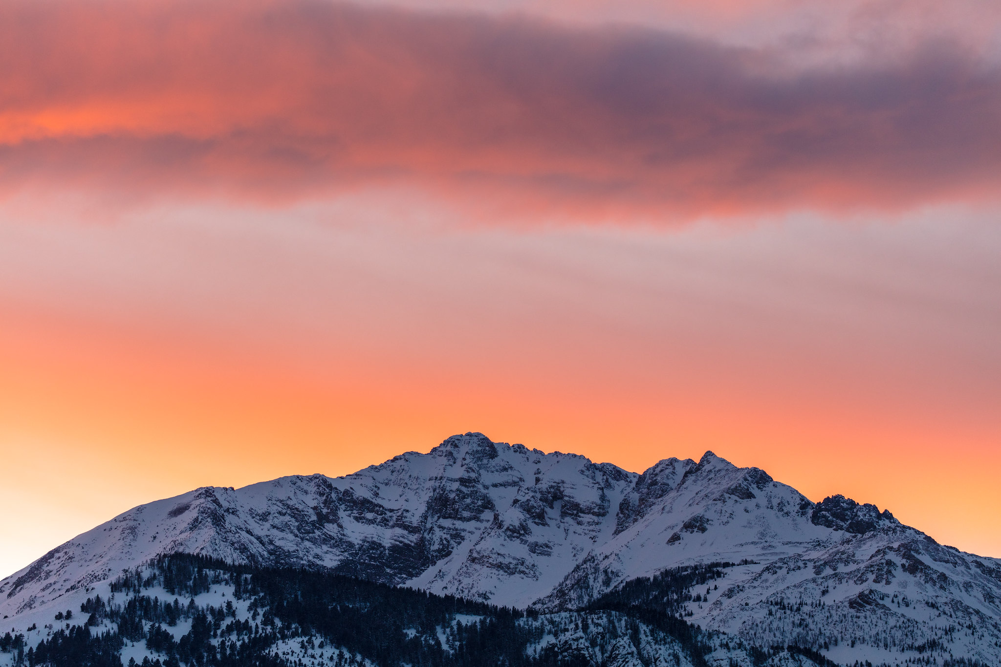 sun sets over a mountain peak