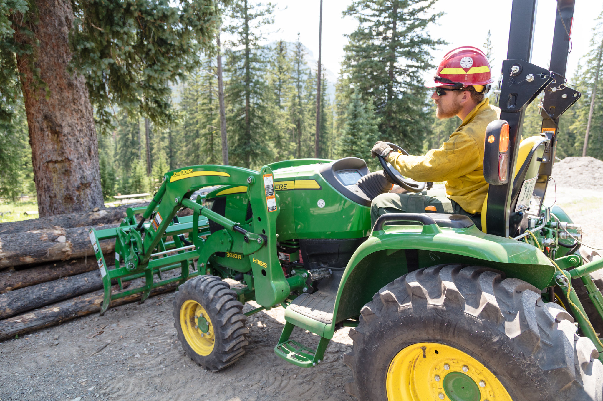 firewood staff using heavy equipment to move logs