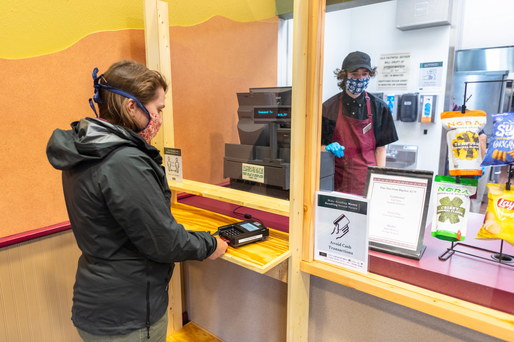 employee assisting visitor with food purchase