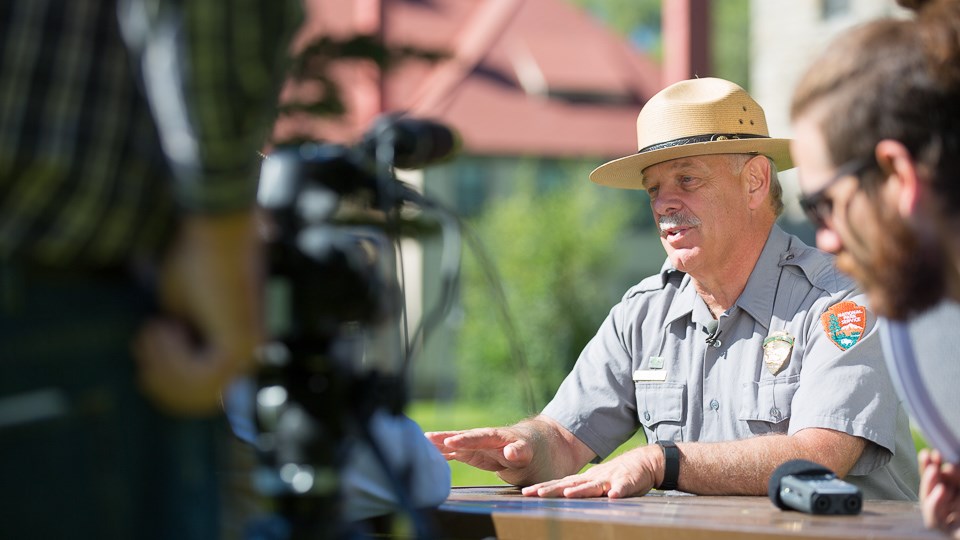 Park ranger being interviewed by journalists. Park ranger being interviewed by journalists.
