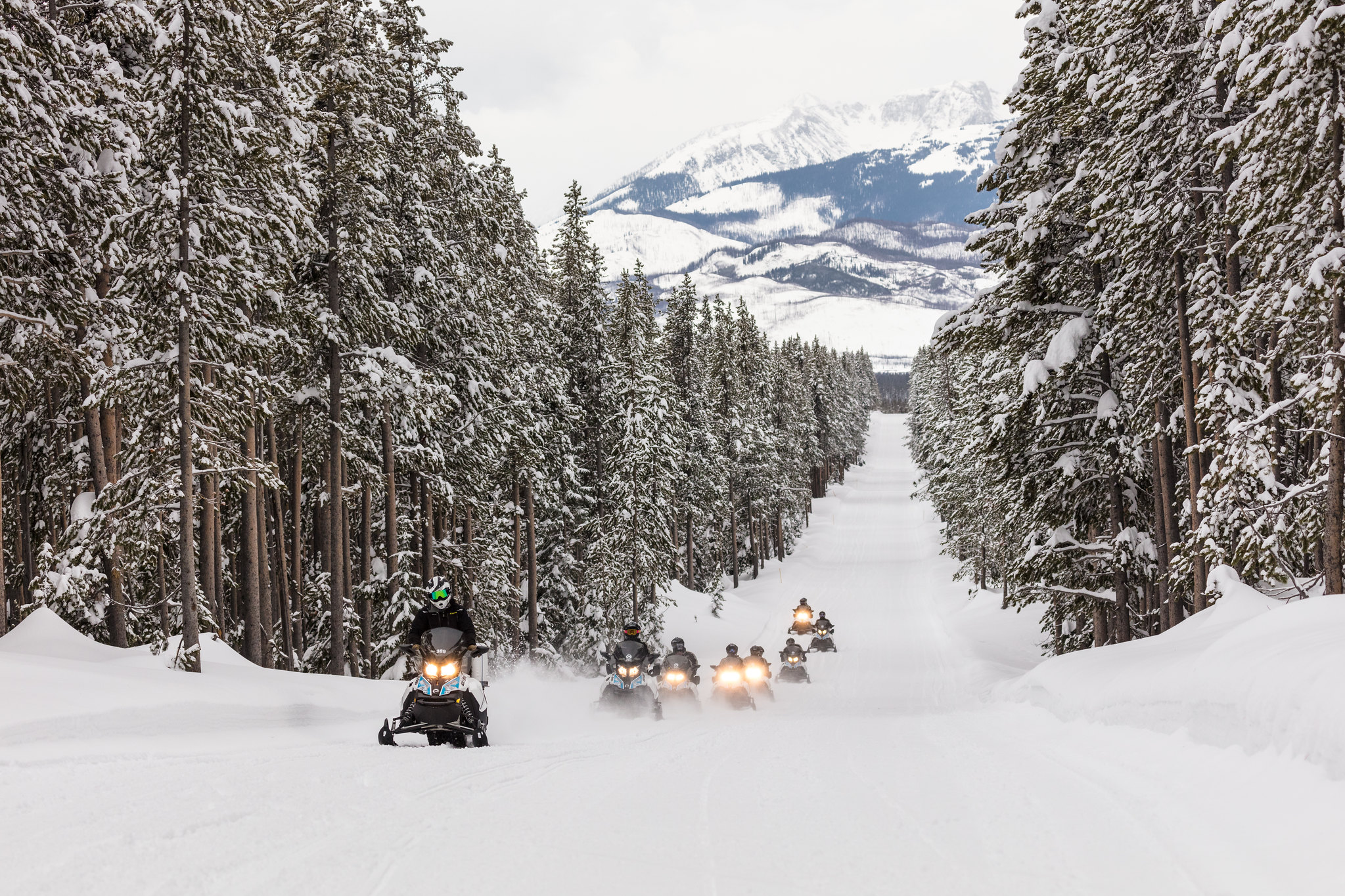 snomobiles a group of snowmobiles on a snowy road