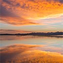 Red and orange clouds reflected in a lake