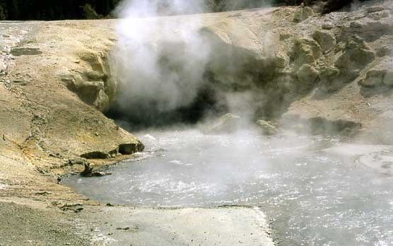 Steam rises from this hot spring which emerges from a small cave.