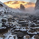 Frost and snow cover rocks in a river