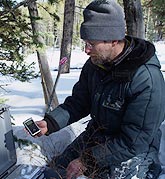 Shan Burson sets up a digital audio recorder on a cold winter day.