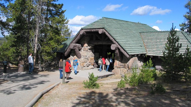 Visitors walking along the cinder path to the open-air, stone and wood museum.