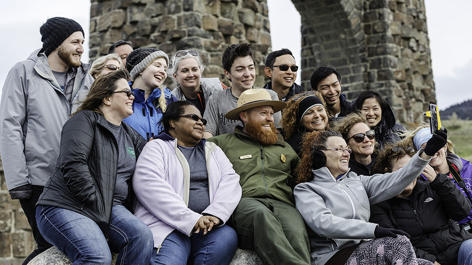 A group of people show their enthusiasm for Yellowstone by taking a group photo. A group of people show their enthusiasm for Yellowstone by taking a group photo.