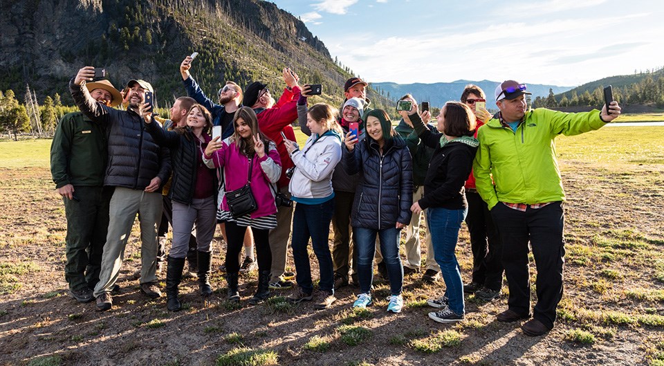 A group of people show their enthusiasm for Yellowstone by taking a group photo.