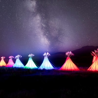 stars light up the night sky above illuminated teepees