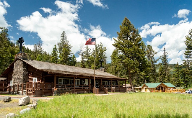 A rustic cabin lodge among large coniferous trees